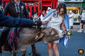 A donkey playfully nibbles the bride’s bouquet as she laughs on a busy street in Galway city centre, Ireland